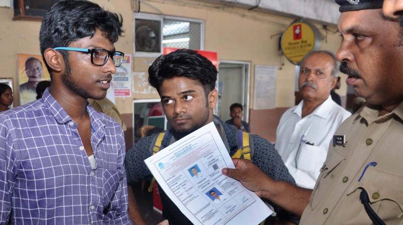 An RPF officer helps candidates from Tamil Nadu find out the NEET centers at South Railway Station in Kochi on Saturday.  (Photo: SUNOJ NINAN MATHEW)