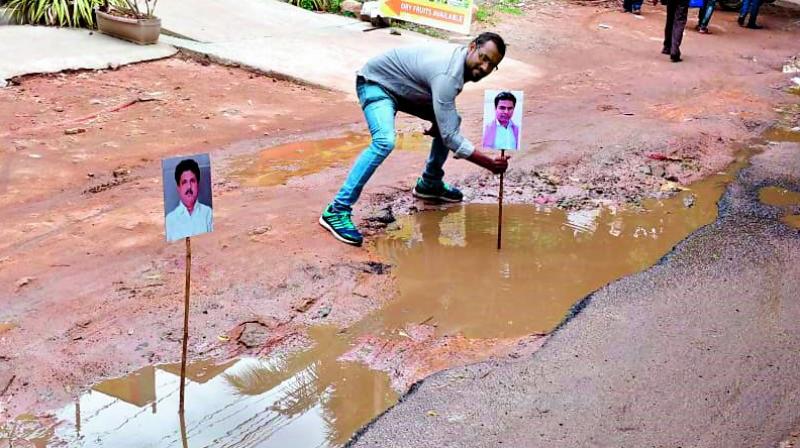 People place photos of minister K.T. Rama Rao and Kukatpally MLA Madhavaram Krishna on top of potholes at KPHB.