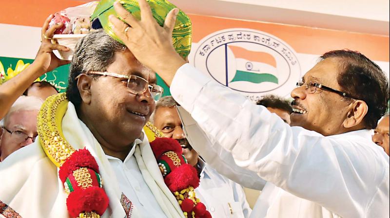 CM Siddaramaiah being felicitated by KPCC president Dr G. Parameshwar for waiving off farm loans, in Bengaluru on Friday. (Photo: DC)