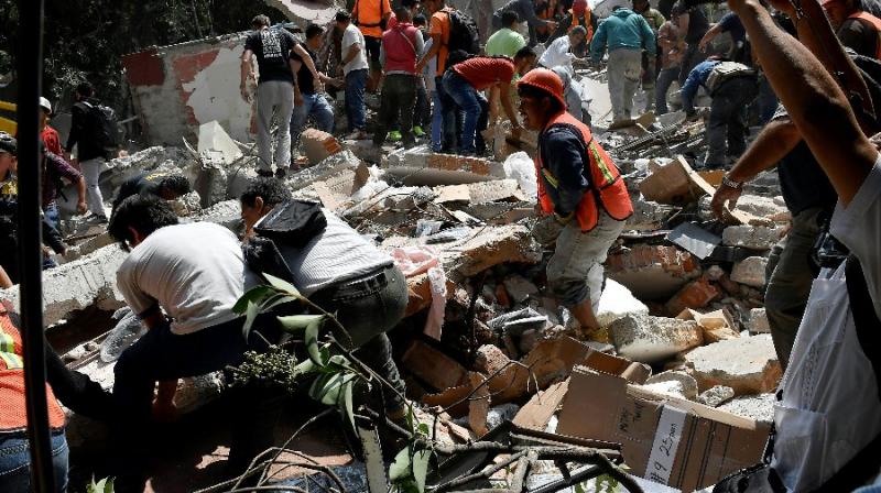 People remove debris of a building which collapsed after a quake rattled Mexico City (Photo: AFP)
