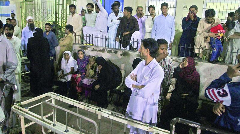 People gather outside an emergency ward of a local hospital after the blast at a Sufi shrine, in Karachi, Pakistan. (Photo: AP)