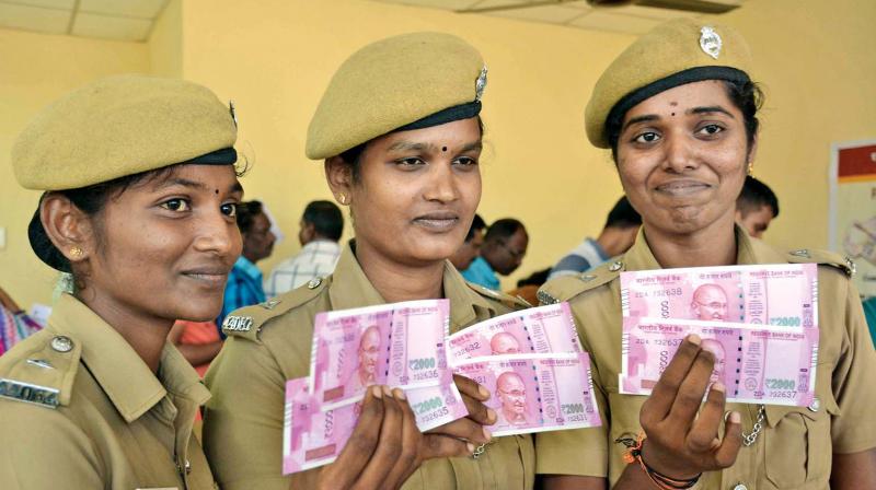 Women cops flaunt their new notes at a Punjab National Bank special currency exchange camp for the police at Rajarathanam Stadium in Egmore on Saturday. (Photo: DC)