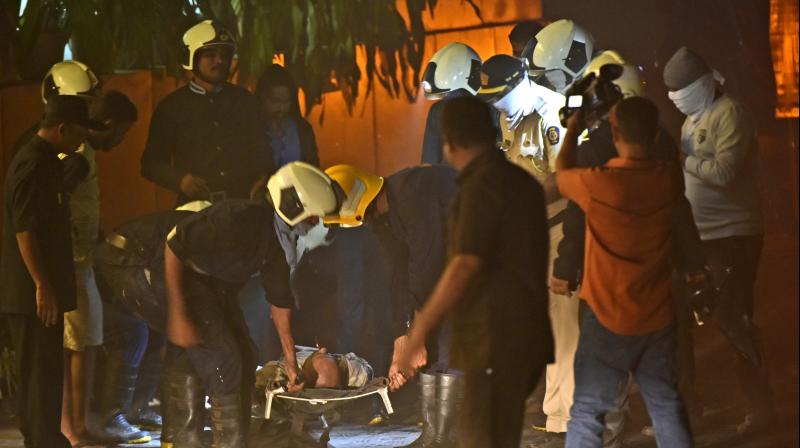 Fire officials carry an injured person in a fire at a restaurant in Kamala Mills Compund. (Photo: AP)