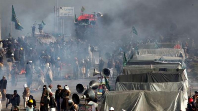 Demonstrators protest as police fire tear gas shells to disperse them during a clash in Islamabad, Pakistan. (Photo: AP)