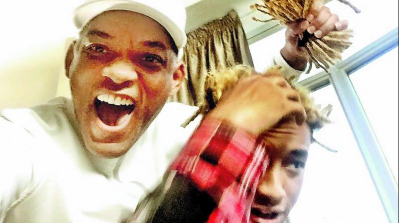 Teamwork: Will Smith poses with Jadens dreads that he chopped off
