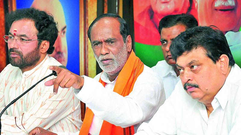 TS BJP president K. Laxman speaks during a press conference at the party office in Hyderabad on Thursday. MLA G. Kishan Reddy and MLC N. Ramachandra Rao are also seen. (Photo: DC)