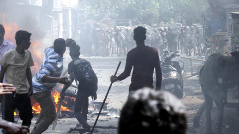 Protestors supporting Jallikattu, a traditional bull-taming ritual throw stones as they clash with police in Chennai. (Photo: AP)