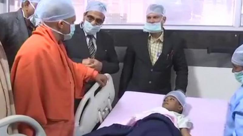 Uttar Pradesh Chief Minister Yogi Adityanath meets 6-year-old buy Hrithik at the hospital. (Photo: ANI)