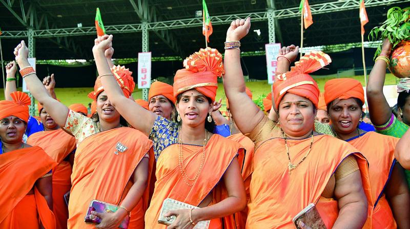 Women dressed in saffron cheer for Prime Minister Narendra Modi ahead of his public meeting at LB Stadium on Monday.   (DC)