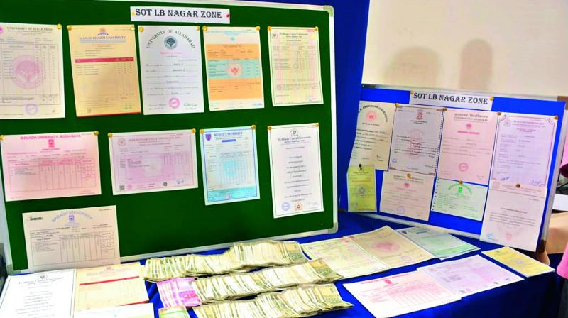 Police display the fake certificates and cash seized from the accused.