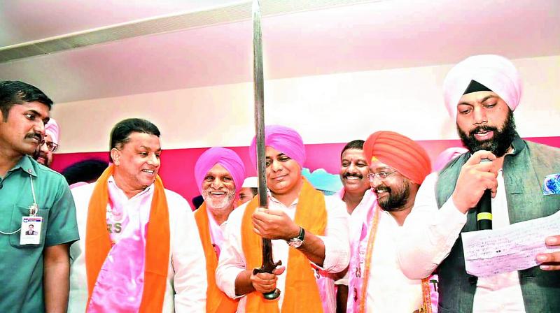Caretaker minister K.T. Rama Rao with members of Sikh community who joined the TRS at an event organised in Hyderabad on Monday.  (DC)