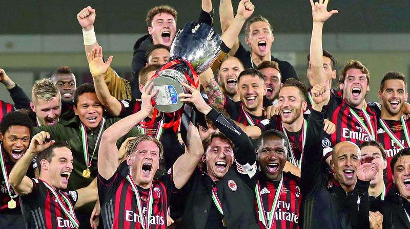 Members of the AC Milan team celebrate with the trophy after winning the Italian Super Cup final against Juventus at the Al Sadd Sports Club in Doha, Qatar, on Friday. AC Milan won 4-3 (1-1) on penalties (Photo: AFP)