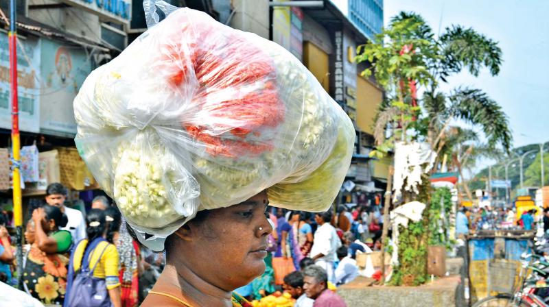 A woman carries flowers in a plastic bag on her head at Parrys flower market. (Photo: DC)