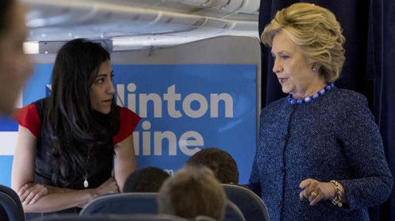 Democratic presidential candidate Hillary Clinton speaks with senior aide Huma Abedin aboard her campaign plane at Westchester County Airport in White Plains. (Photo: AP)