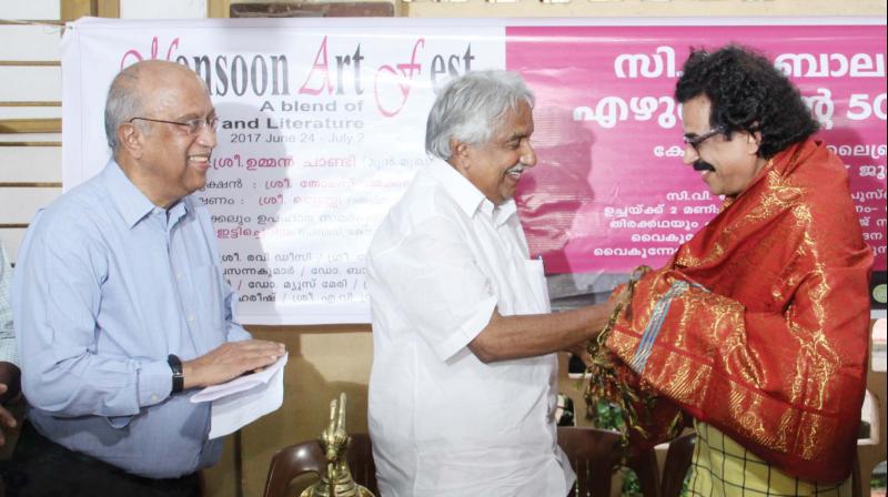 Former chief minister Oommen Chandy honours C.V. Balakrishnan while senior journalist Thomas Jacob looks on, at function in Kottayam on Saturday. (Photo: Rajeev Prasad)