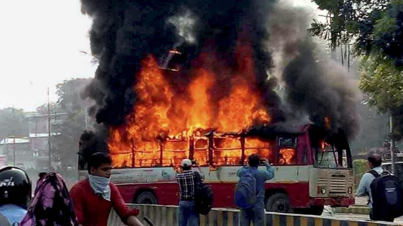Angry mob set a bus on fire after Bahujan Samaj Party (BSP) leader Rajesh Yadav was shot dead outside an Allahabad University hostel. (Photo: PTI)
