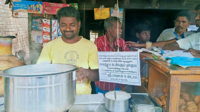 Sivakumar at his tea shop in Vamban village near Pudukkottai with the announcement board on the loan write-off to his left. (Photo: DC)
