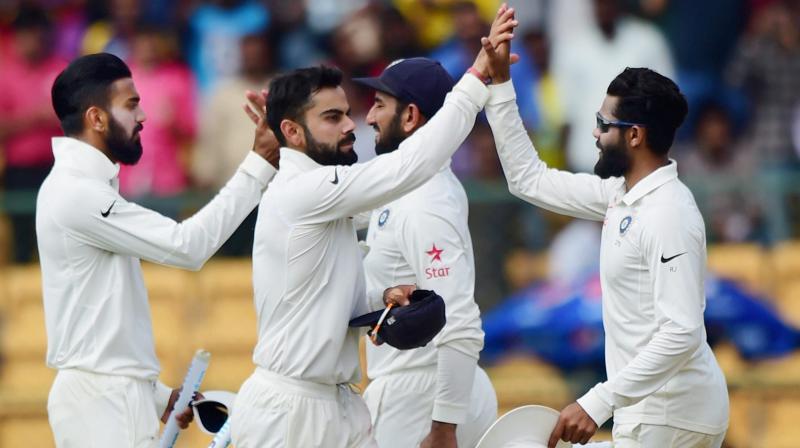 Indian captain Virat Kohli celebrates with team mates after beating Australia in the second test match at Chinnaswamy stadium in Bengaluru on Tuesday. (Photo: AP0