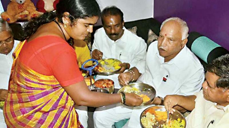 BJP Karnataka chief B.S. Yeddyurappa, along with party leaders, having a breakfast at the house of a Dalit at Kakri Basaveshwar Nagar in Hubballi.