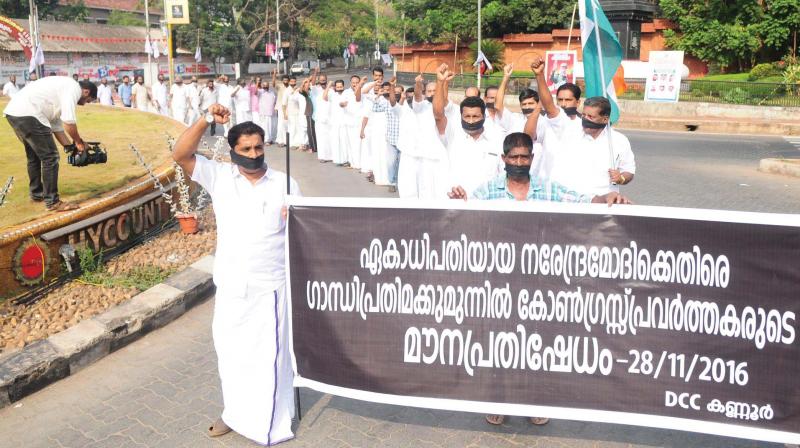 Congress workers stage a silent protest in front of Gandhi statute in Kannur as part of its nation-wide protest against the demonetisation. (Photo: DC)