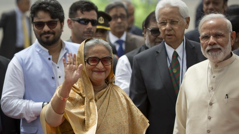 Bangladeshi Prime Minister Sheikh Hasina waves to media as her Indian counterpart Narendra Modi watches on her arrival in New Delhi. (Photo: AP)