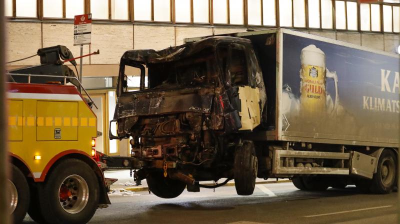 A destroyed truck is pulled away by a service car after it was driven into a department store in Stockholm, Sweden. (Photo: AP)