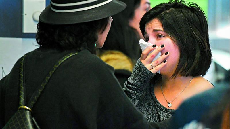 A woman of Iranian origin cries as she waits for word on relatives at Los Angeles airport. (Photo: AFP)