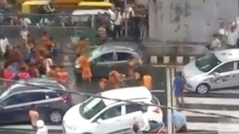Kanwariyas thrash a car in New Delhi.