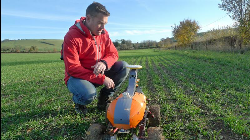 Joe Allnutt, lead roboticist at British startup company the Small Robot Company, inspects a farming robot named Tom as part of a trial in East Meon, southern England, Friday Nov. 30, 2018. The â€œagri-techâ€ startup company is developing lightweight autonomous machines that can carry out precision â€œseeding, feeding and weedingâ€ in the hope of transforming food production. (AP Photo / Kelvin Chan)