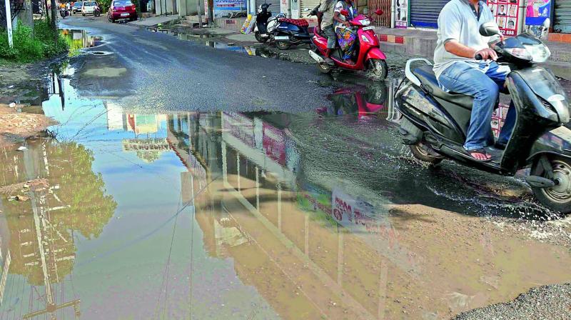 Commuters try to avoid water from a sewer overflowing since the past 20 days at Suryaraopet in Vijayawada on Monday. (Photo: DC)