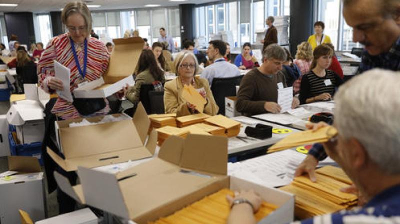 Volunteers and election officials take part in the ballot counting process for all of the Hennepin County cities, except Minneapolis. (Photo: AP)