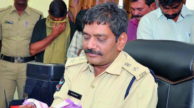 DCP G. Palaraju inspects the cash seized from 12 people involved in exchange of old currency notes at Suryaraopet PS in Vijayawada.