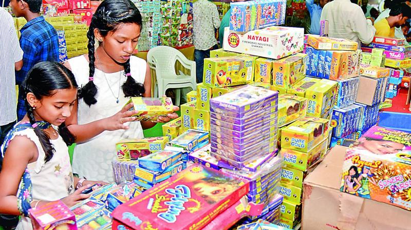 Children buy fire crackers from a shop in Hyderabad on Tuesday.(Photo: S. Surender Reddy)