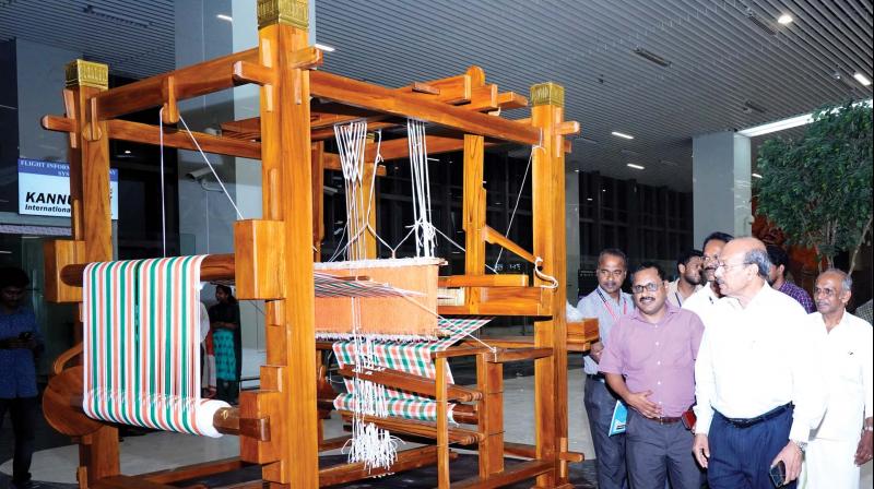 The officials of Kannur international airport and the Kerala Handloom Development Board examine the newly installed model of loom at airport on Thursday.