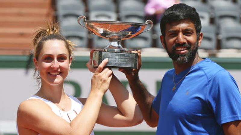 Canadas Gabriela Dabrowski and Indias Rohan Bopanna hold the trophy as they celebrate winning their mixed doubles (Photo: AP)