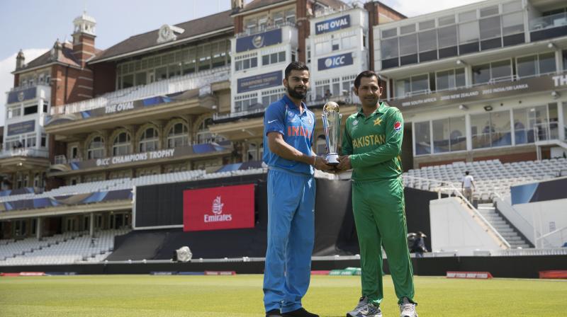 Indias captain Virat Kohli, left, and Pakistans captain Sarfraz Ahmed pose for a picture with the trophy at the Oval cricket ground in London. (Photo: AP)