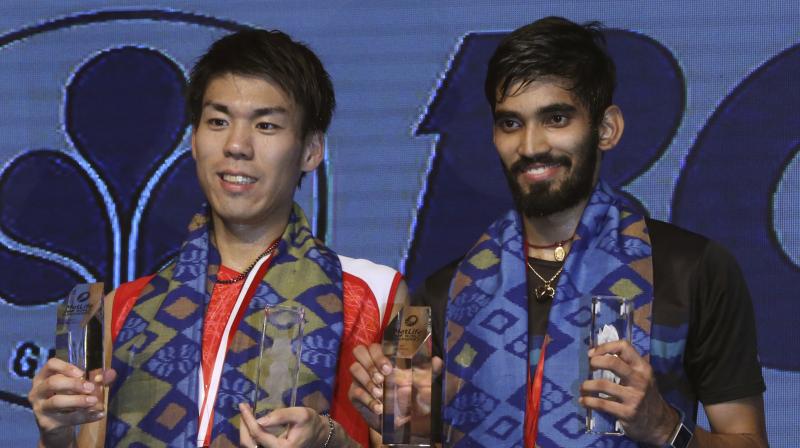 Indias Srikanth Kidambi, right, and Japans Kazumasa Sakai show their trophies after their mens singles final match at Indonesia Open badminton championship in Jakarta. (Photo:AP)