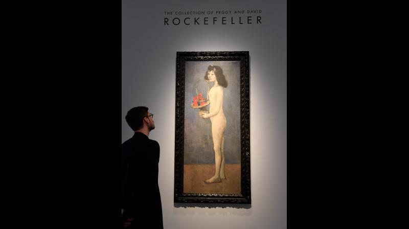 A man looks at the painting \Fillette   la corbeille fleurie\ 1905 by late Spanish painter Pablo Picasso at Christies France, as part of a presentation of the collection Rockefeller in Paris on March 13, 2018, before the sale at Christies New York. (Photo: AFP)