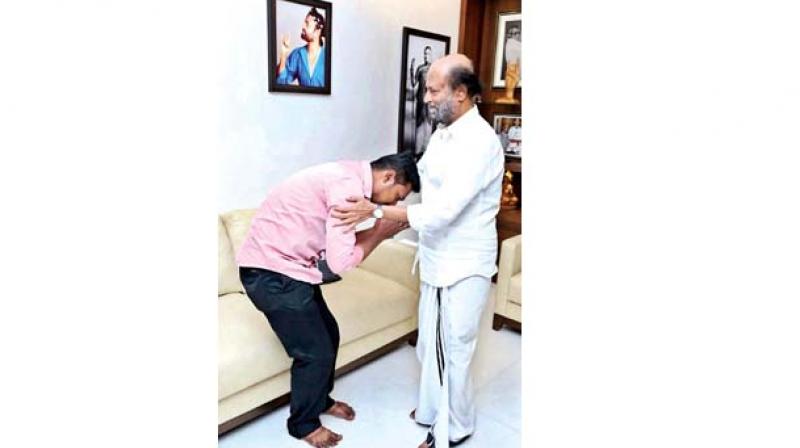 Rajinikanth consoling Vijayakumar, father of the two kids poisoned by his wife.	(Image: DC)
