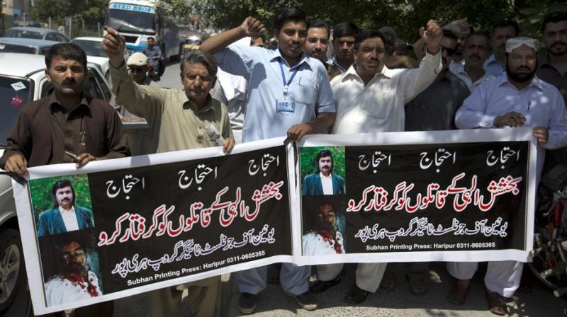 Pakistani journalists protest holding banners reading \arrest killers of Bakhsheesh Elahi.\ in Haripur , Pakistan. (Photo:AP)