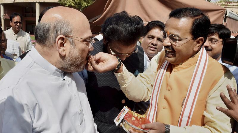 BJP President Amit Shah is offered sweets to Uttar Pradesh BJP President and party MP Keshav Prasad Maurya at Parliament House in New Delhi. (Photo: PTI)