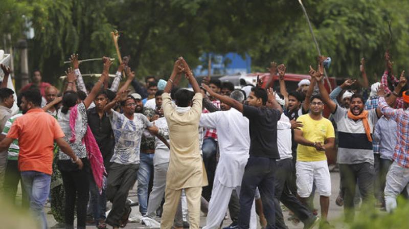 Supporters, back toward camera, try to calm other supporters of the Dera Sacha Sauda sect near an Indian court in Panchkula, on Friday. (Photo: PTI)