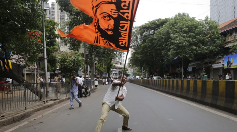 A Maratha community member waves a flag with a portrait of Shivaji, the founder of Maratha dynasty, during a protest in Mumbai. Protests are being held in different parts of Maharashtra state by the community to demand reservation in government jobs and education. (Photo: AP)