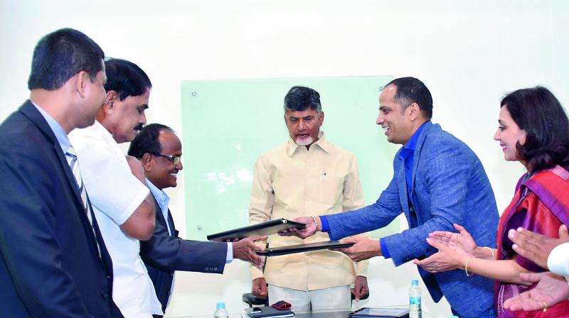 Officials of the Government of AP and Monetary Authority of Singapore sign an MoU on Fintech  in the presence of Chief Minister N. Chandrababu Naidu at his house in Vijayawada on Saturday. (Photo: DC)