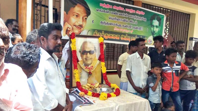 Thirukuvalai villagers pay  floral tributes to a portrait of Karunanidhi outside his house on Wednesday (Photo: DC)