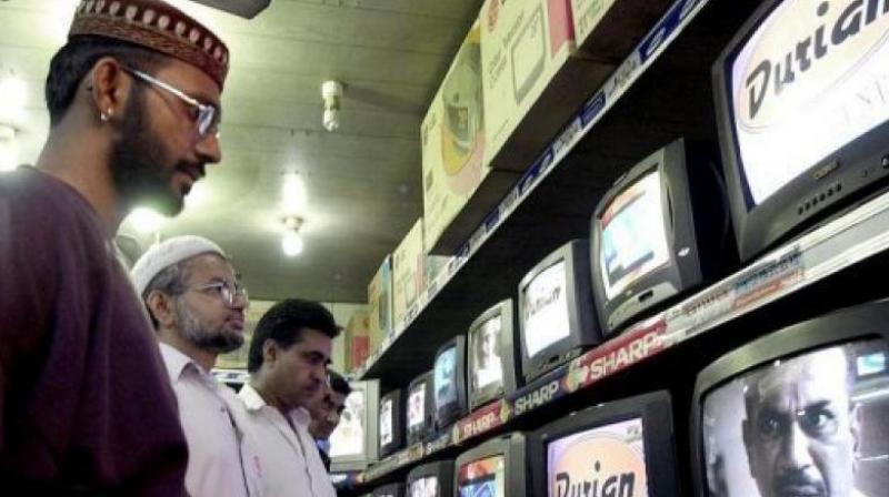 People watch TV programes in Karachi. (Photo: AFP)