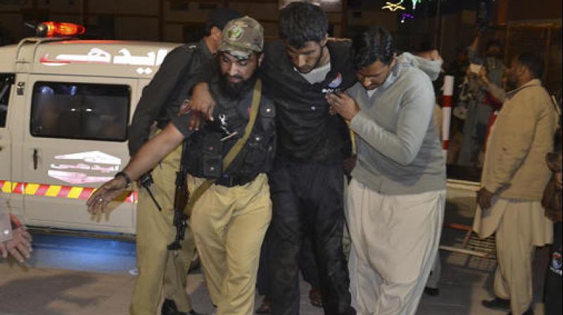 A Pakistani volunteer and a police officer rush an injured person to a hospital in Quetta, Pakistan. (Photo: AP)