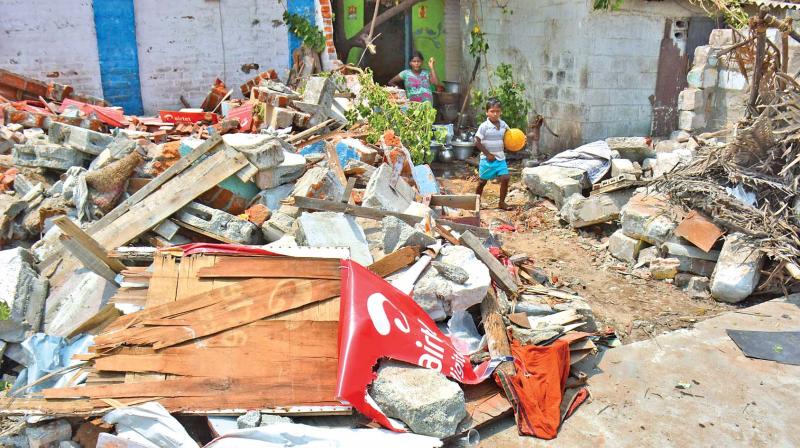 Children walk through rubble left behind by corporation staff who demolished houses at Pattinampakkam on Saturday, in order to extend the road.  The residents were provided rehabilitation at Perungudi, around 11km away from Pattinampakkam.