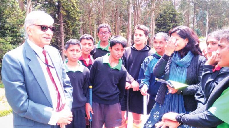 Noted journalist and columnist Anand Sahay, an alumnus of Lawrence School , is seen giving hockey playing tips to the  students.  (Photo: DC)