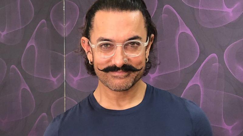 Aamir Khan poses with a pad.
